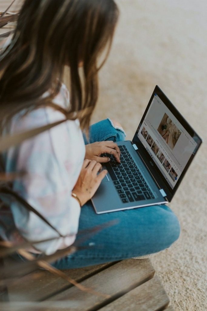 Woman using laptop for Google Ads marketing.