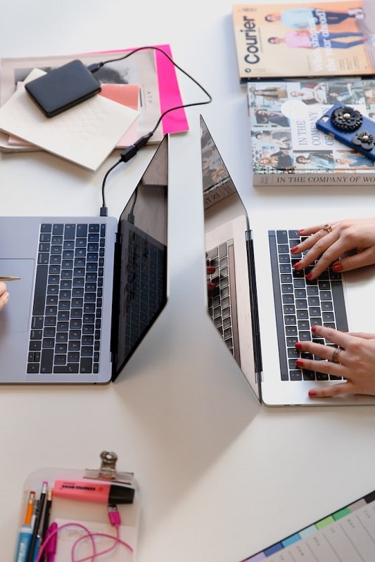 2 Laptops placed back-to-back on a table used by digital marketing agency.