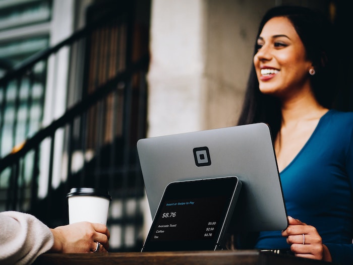 Woman smiling while using her laptop due to the increase of local SEO website traffic.